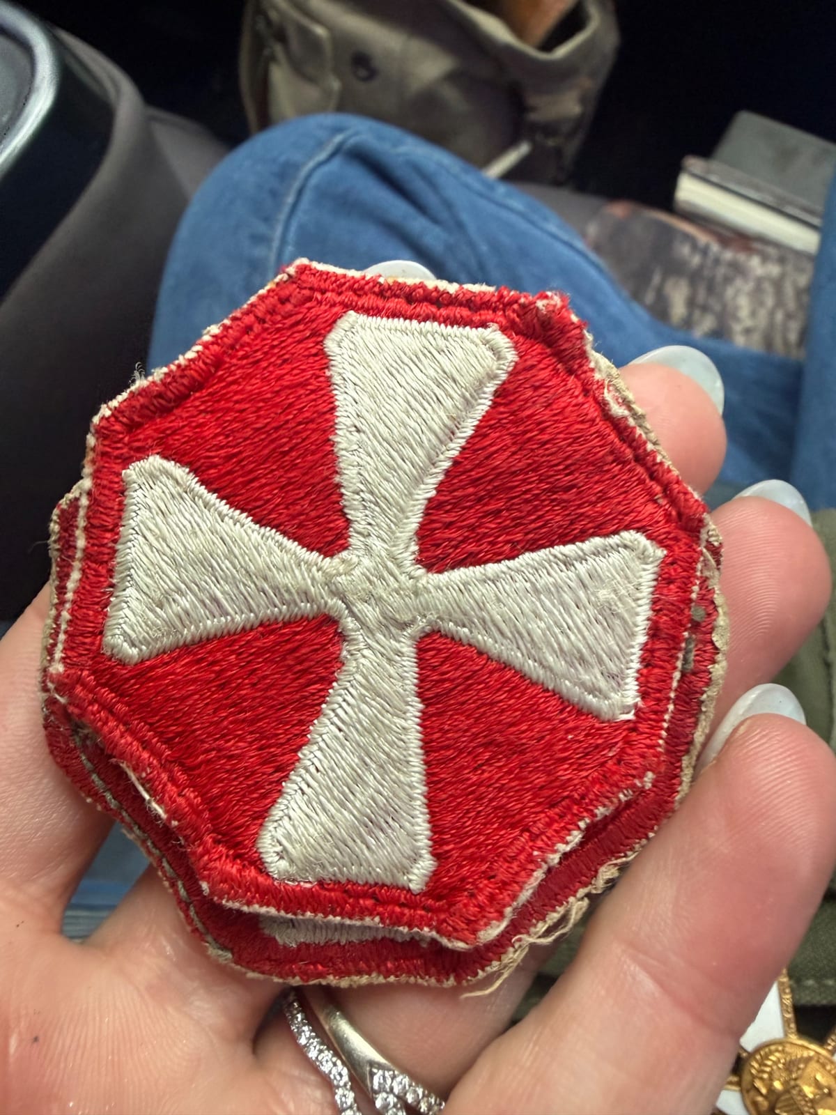 Embroidered military insignia patch with white cross on red octagonal field