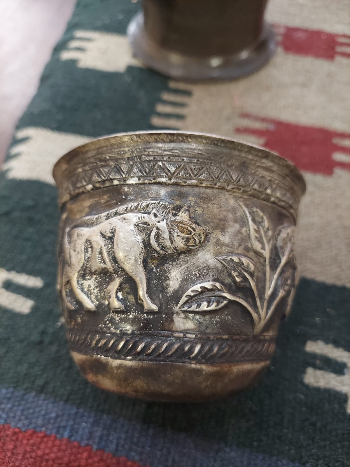 Decorative silver-colored cup or small beaker with repoussé animal motif