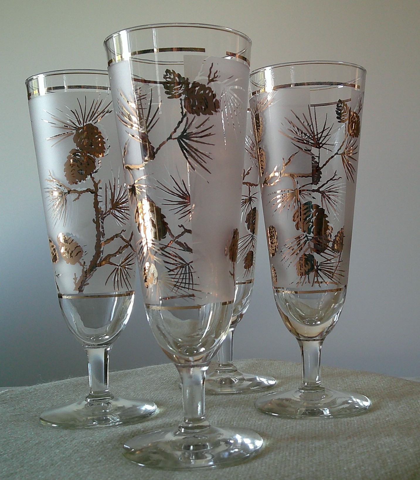 Set of etched and gilt champagne flutes with pinecone motif