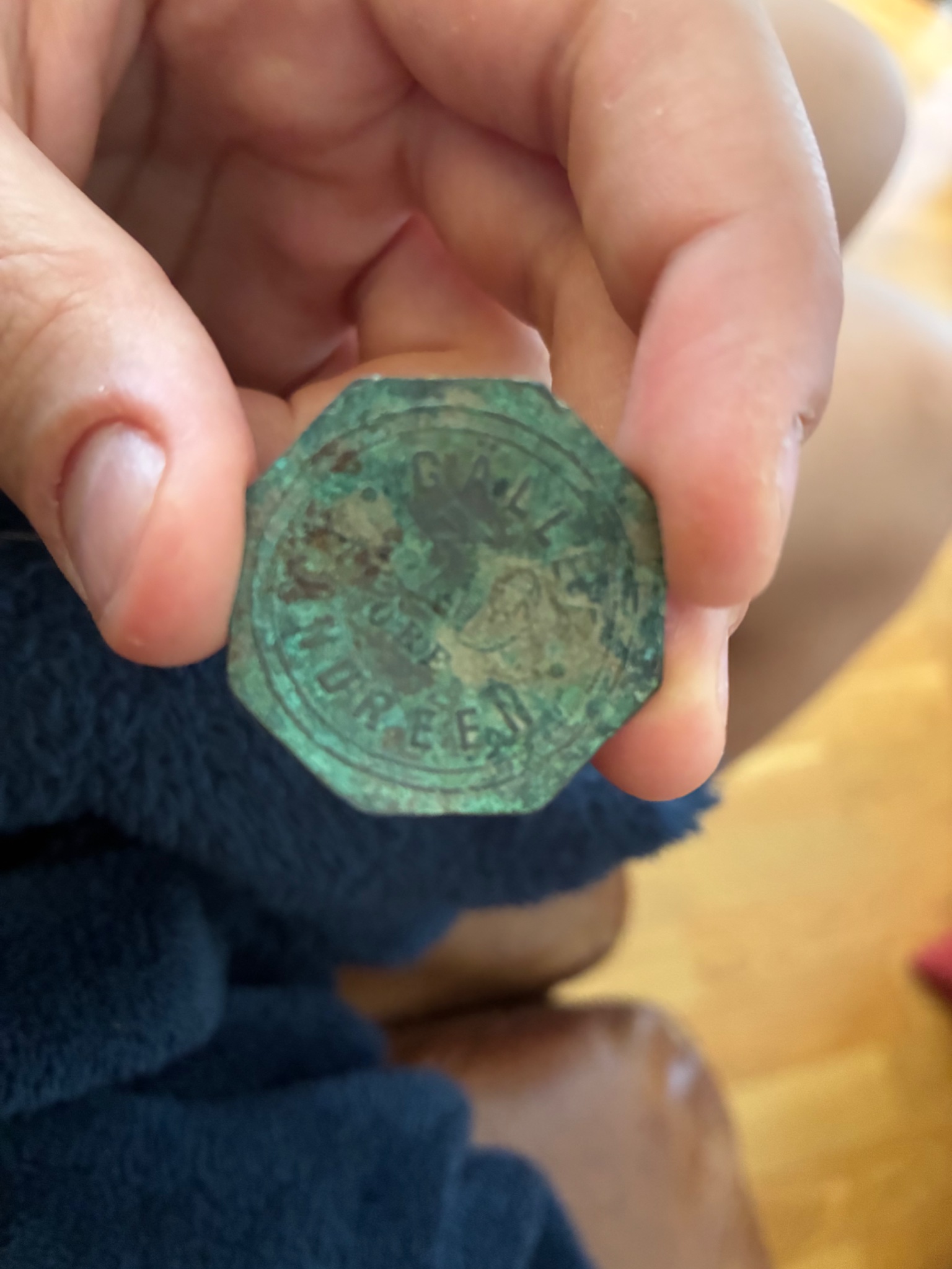 Octagonal brass/bronze token or seal-like medallion with green patina