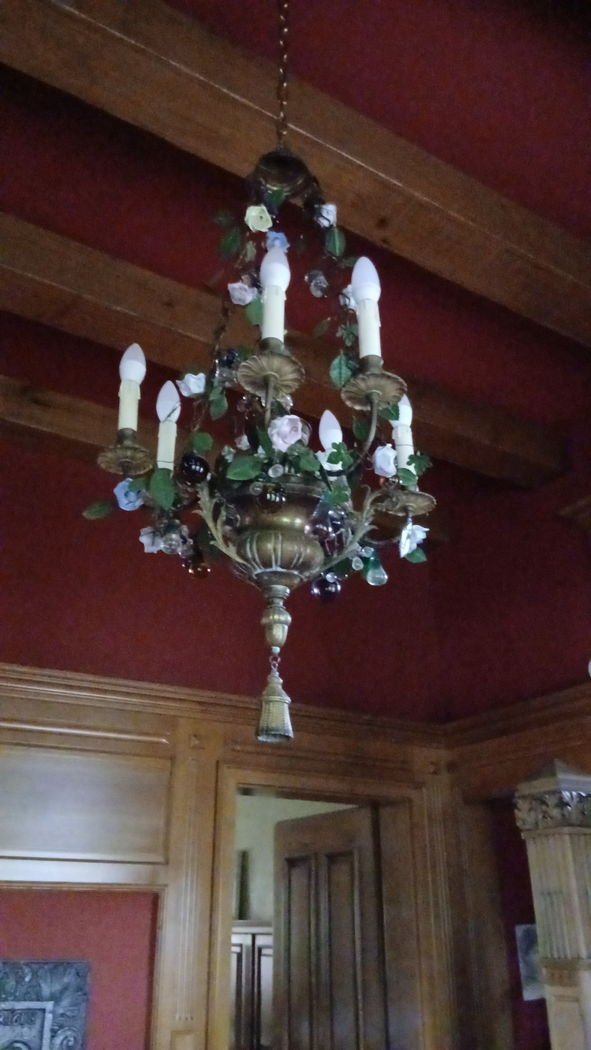 Ornate brass chandelier with floral glass/porcelain embellishments