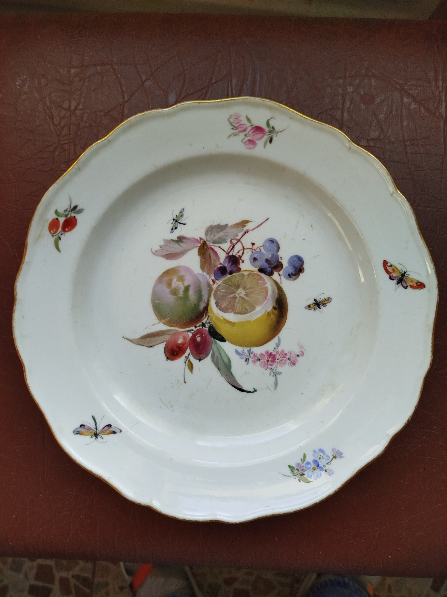 Decorative porcelain dessert plate with hand-painted fruit and butterfly motifs