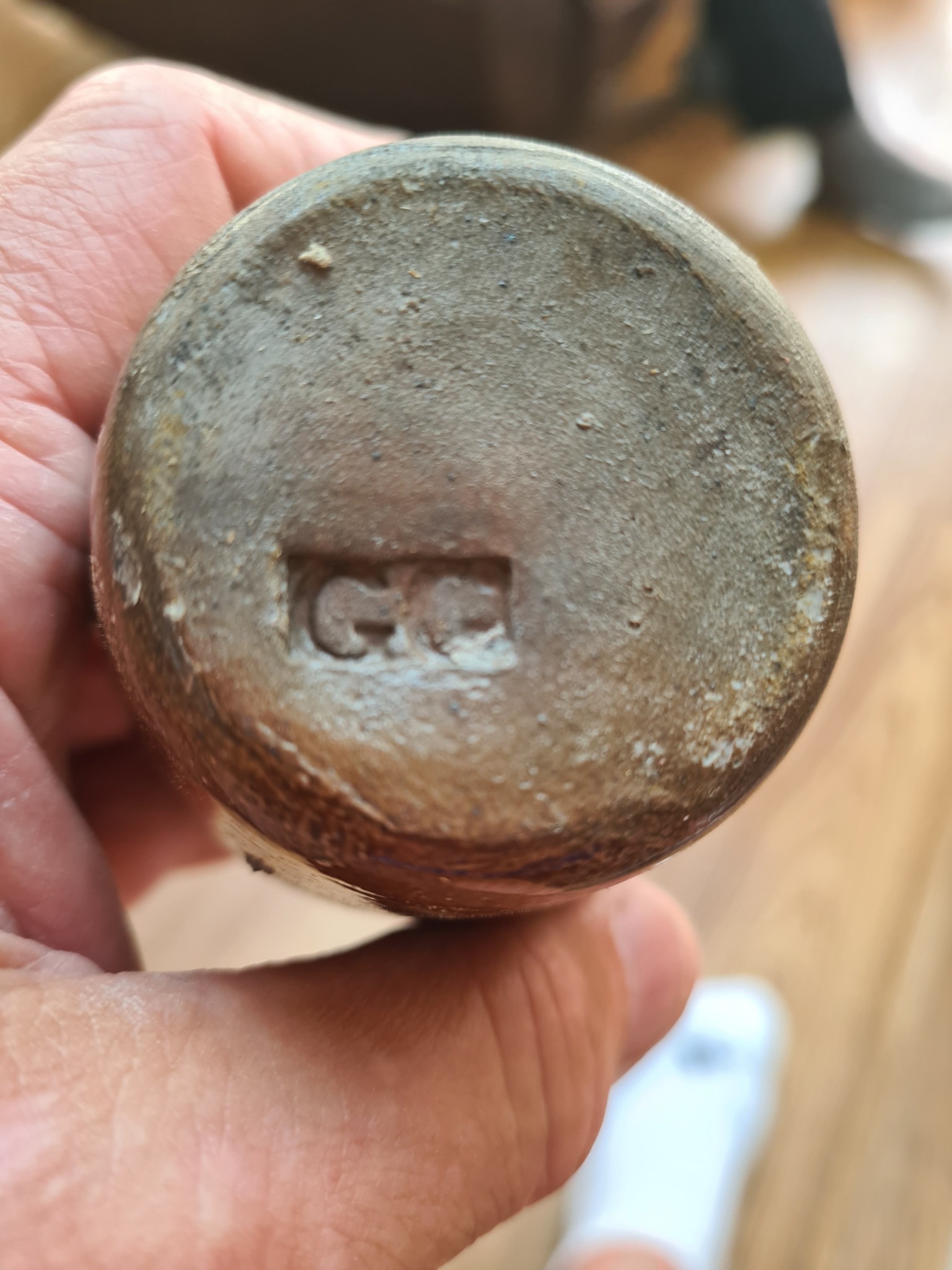 Unknown cast-metal or ceramic vessel base with maker's mark
