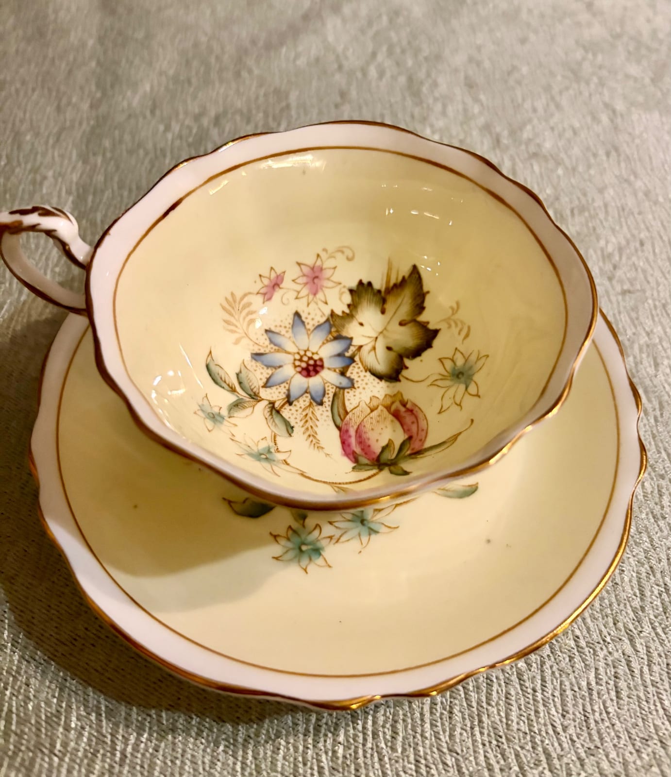 Porcelain teacup and saucer with floral decoration and gilt trim