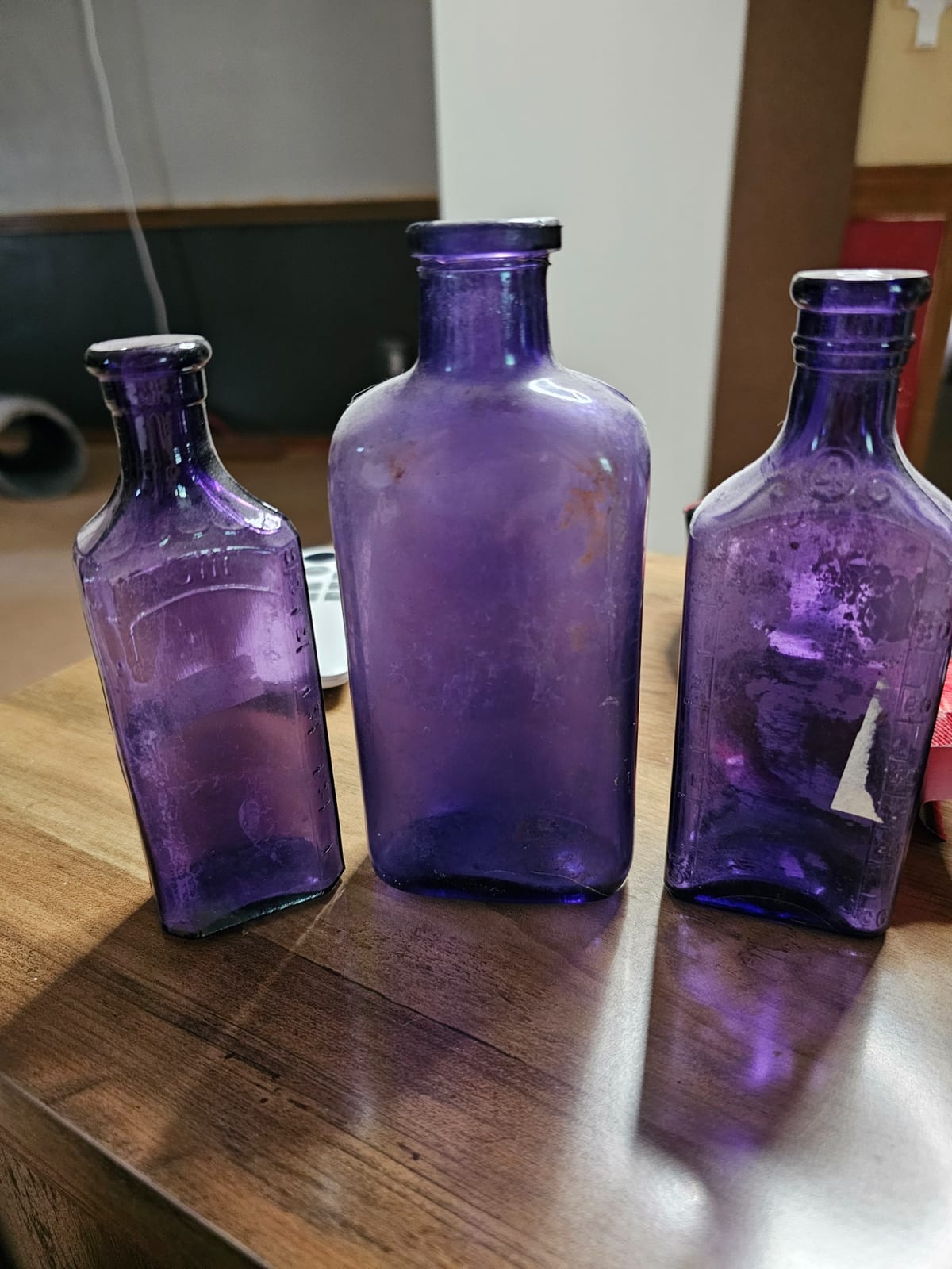 Three purple glass medicine/apothecary bottles