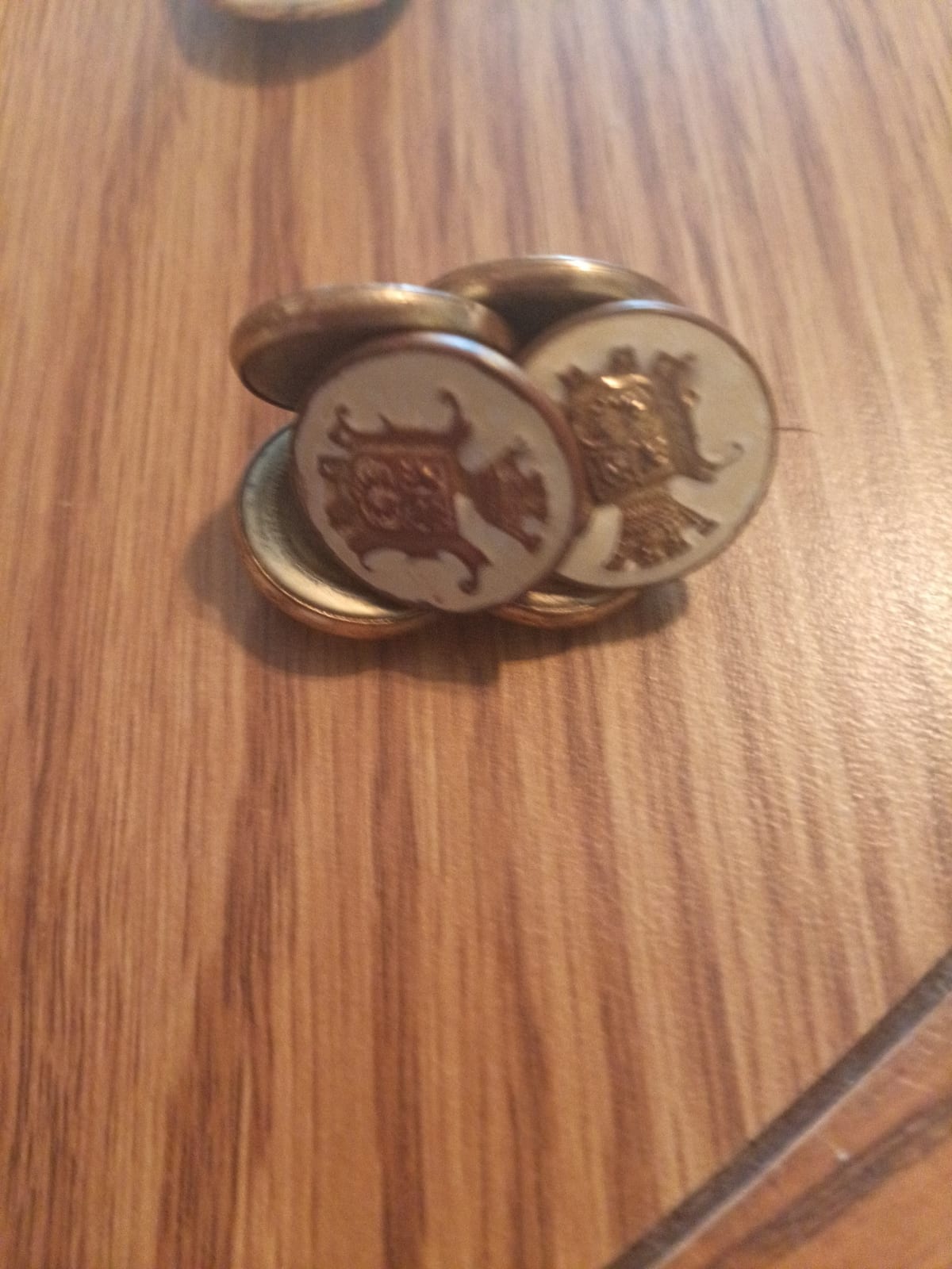 Pair of decorative cufflinks with heraldic/crest-style enamel or inlay faces