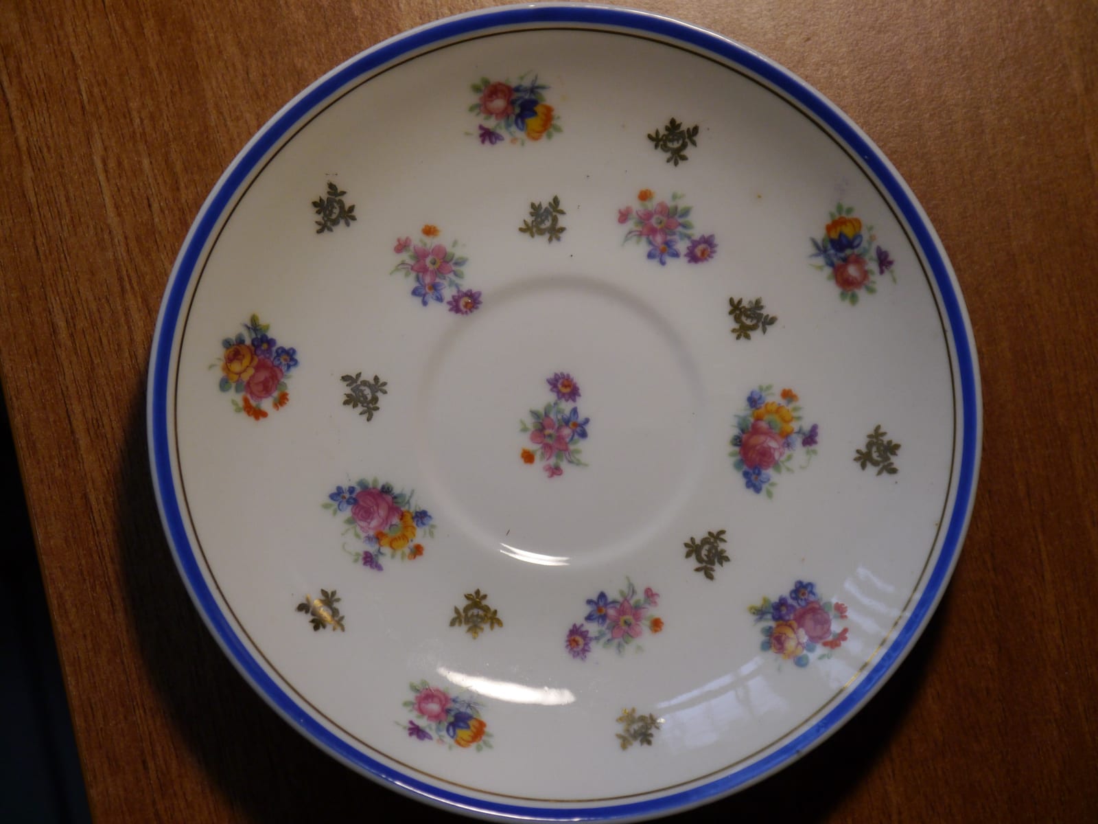 Porcelain saucer or small plate with floral and gilt decoration