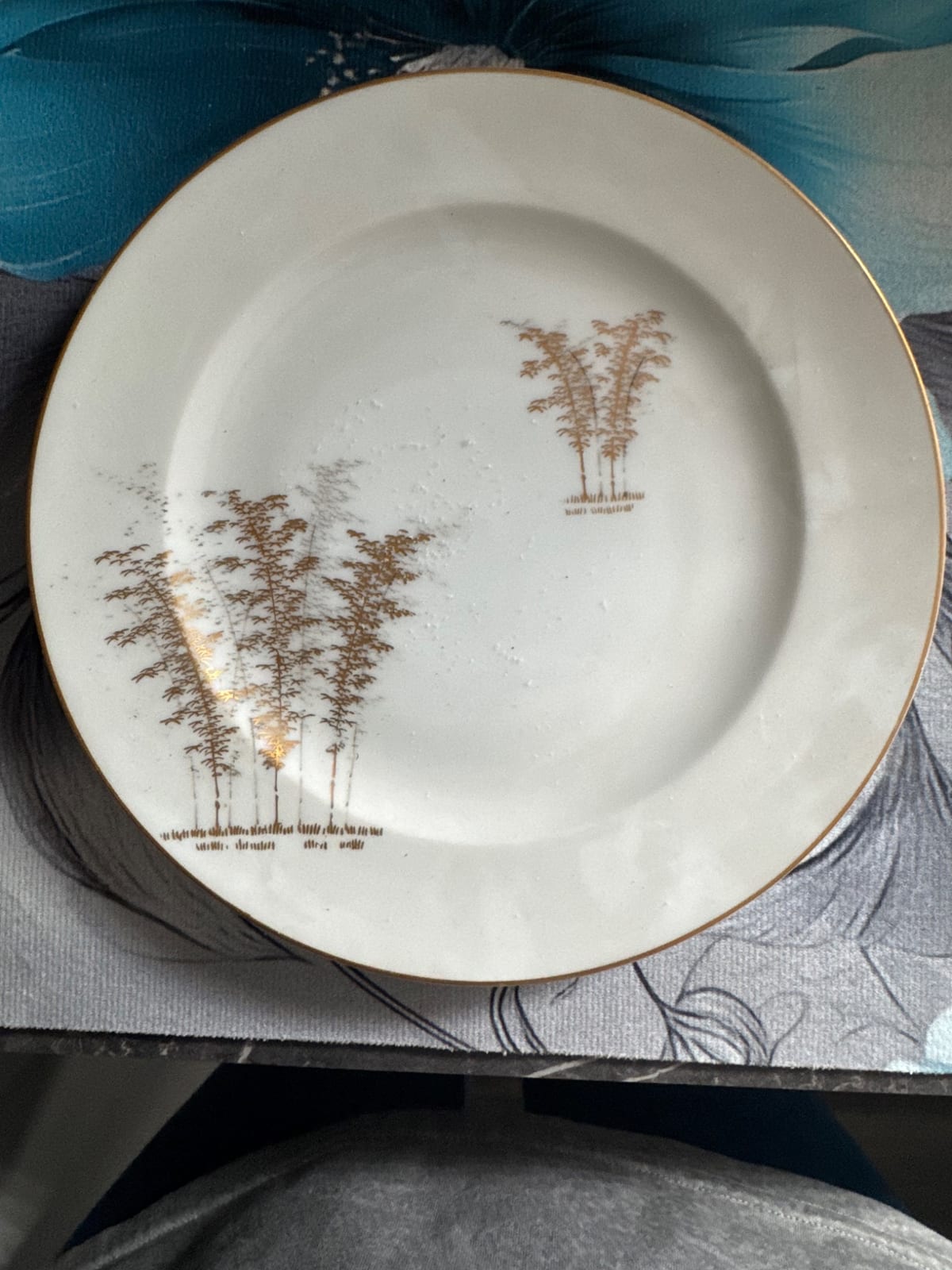 Decorative porcelain dinner plate with gilt rim and bamboo/tree motif