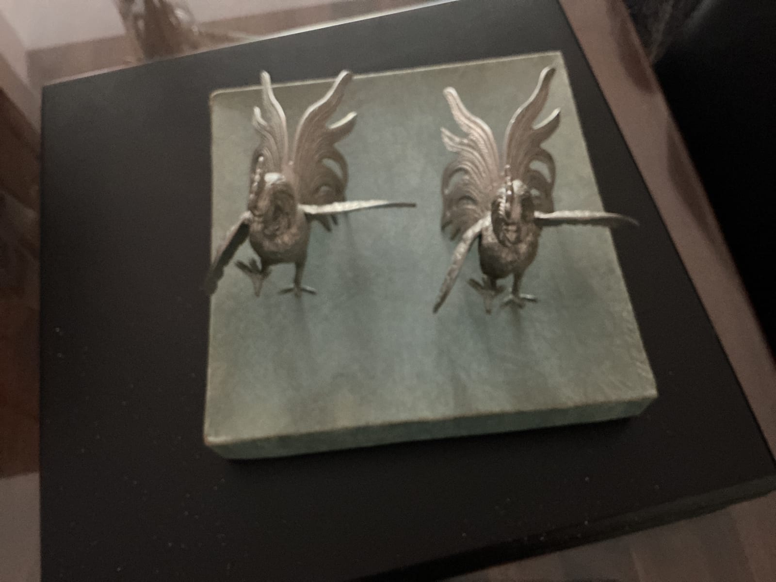 Pair of decorative bird-form metal sculptures on a stone or composite base
