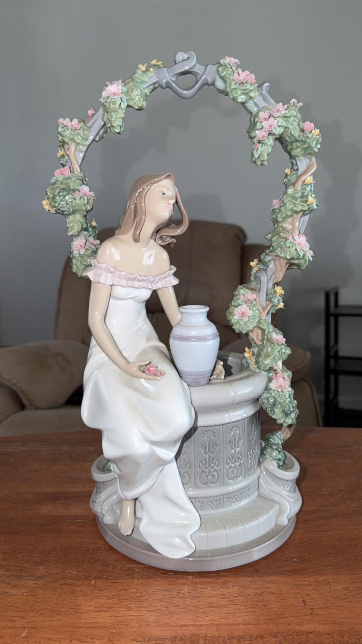 Decorative porcelain figurine with wishing well and floral arbor