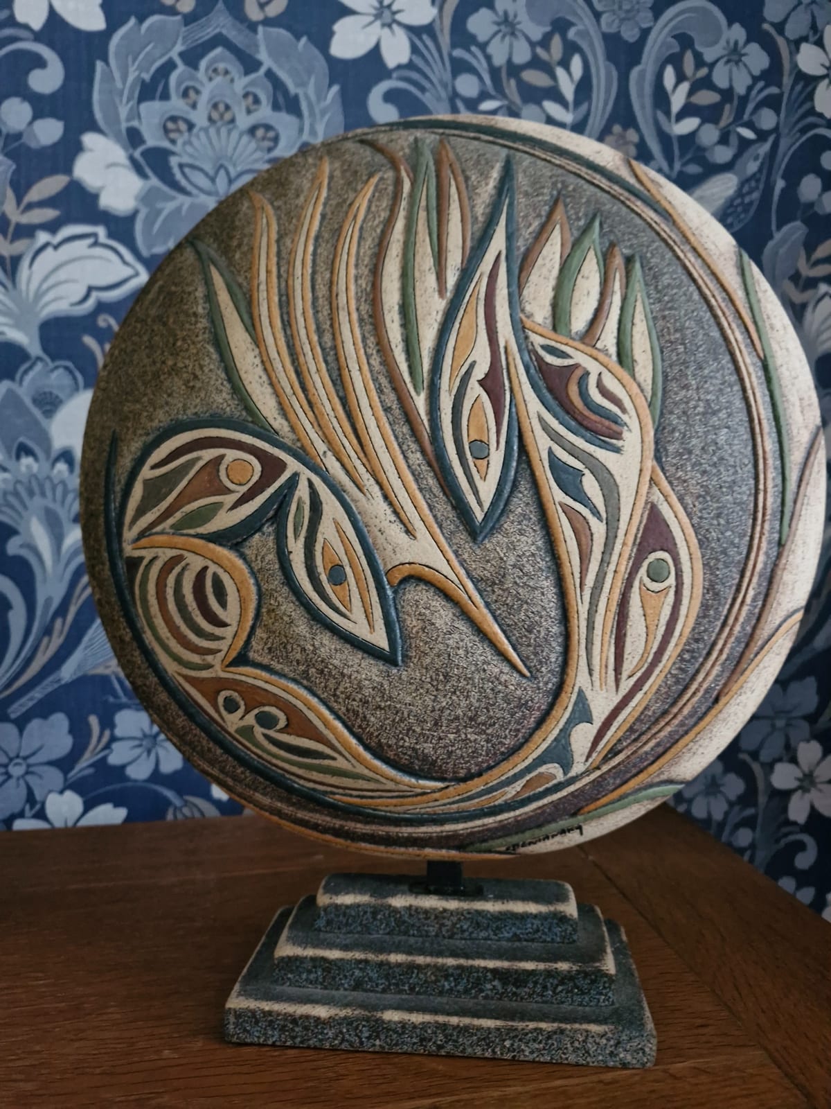 Decorative carved stone or composite art plaque on display stand