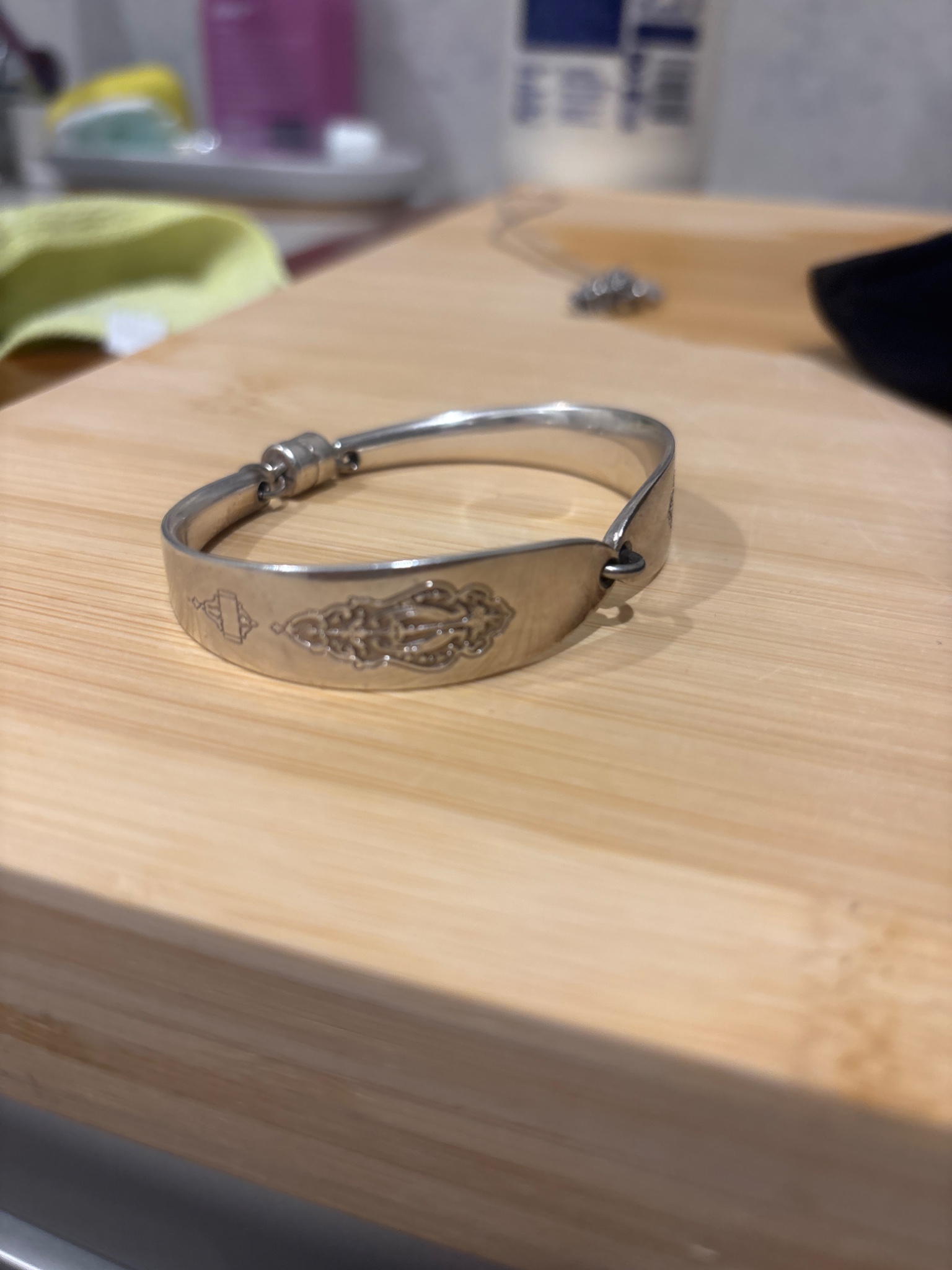 Silver-tone hinged bangle bracelet with engraved decorative motif