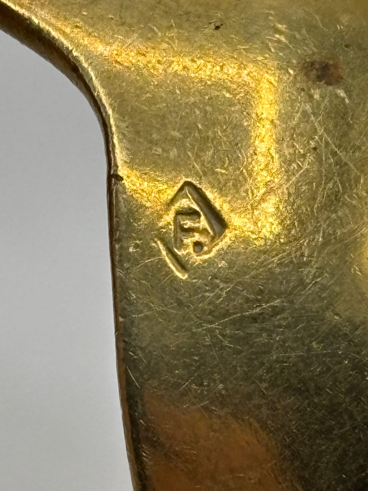 Gold-colored metal vessel or decorative object with maker's mark