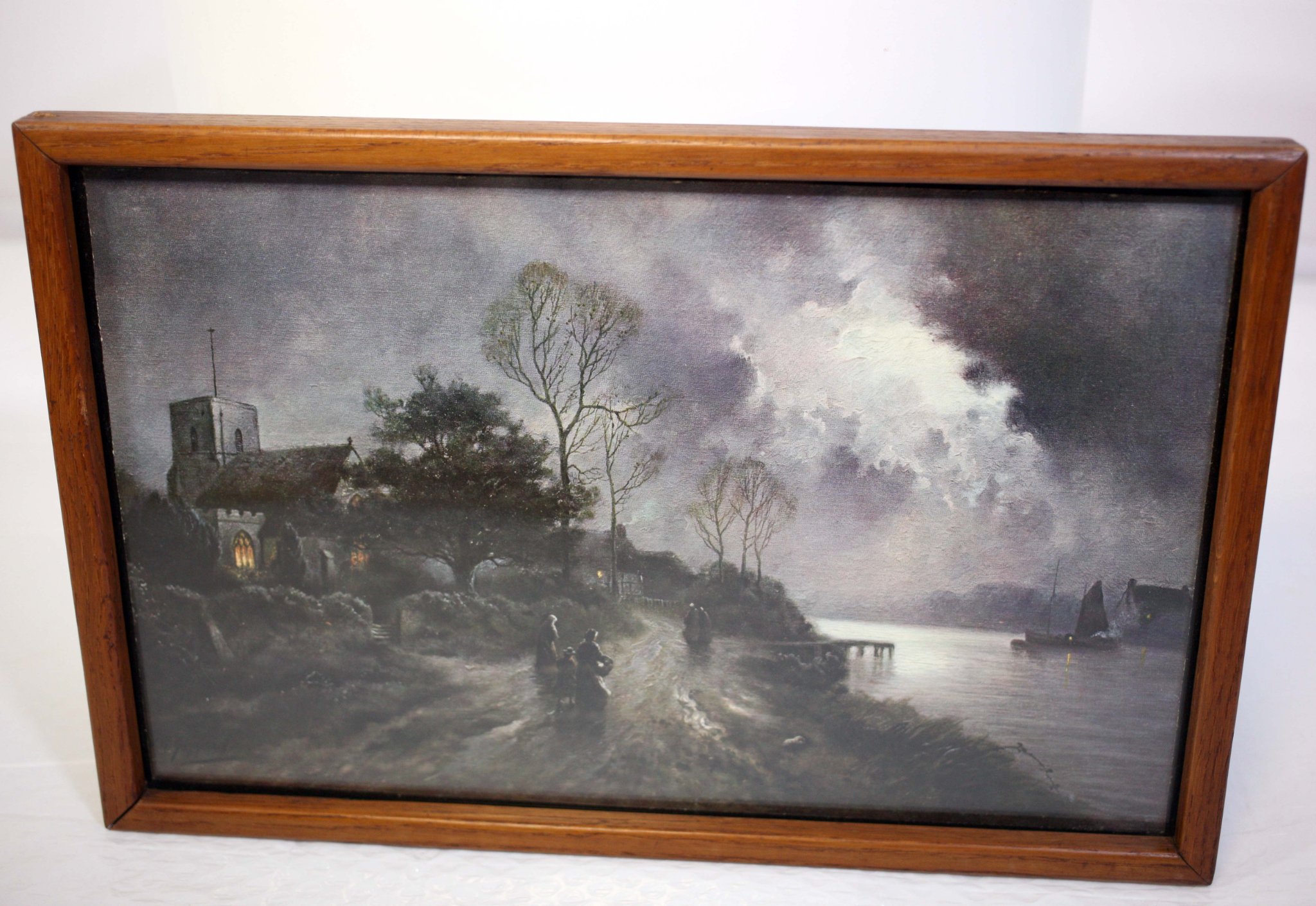 Framed landscape print or painting depicting a moonlit riverside church scene