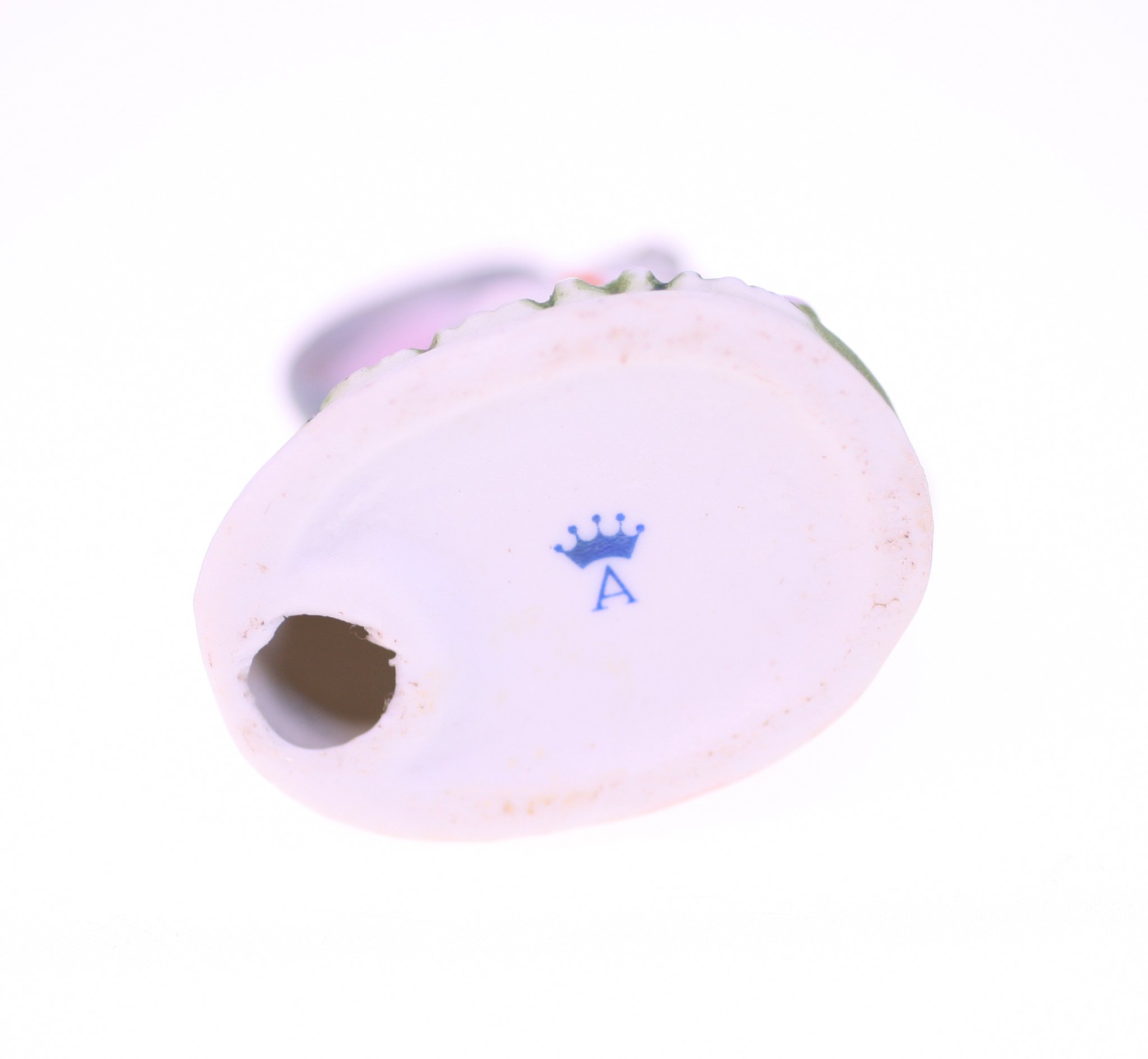 Small porcelain figurine or decorative ceramic object (possibly a perfume bottle stopper or miniature vase)