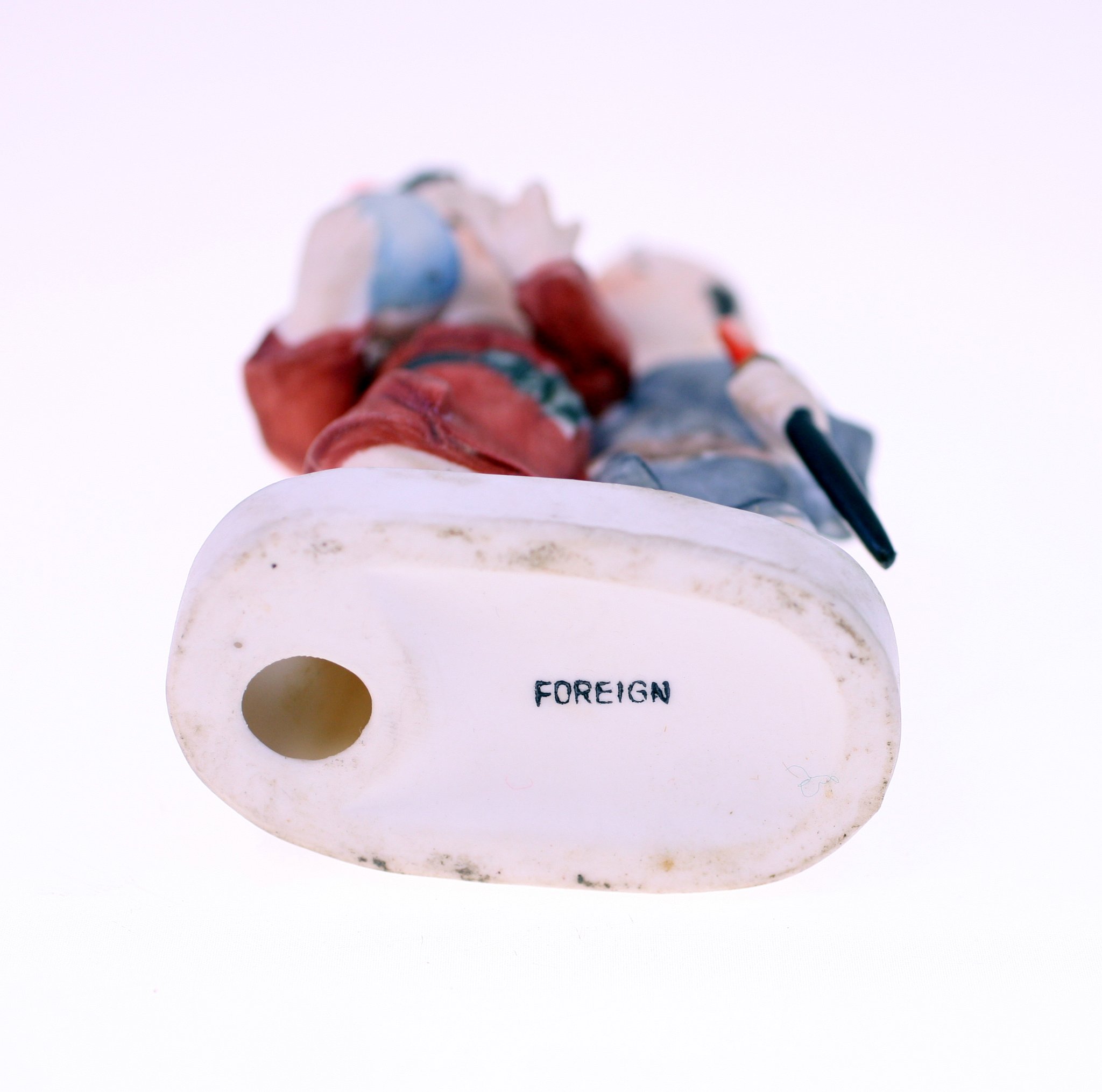Small porcelain figurine of a traditional figure (likely Japanese or European export style)