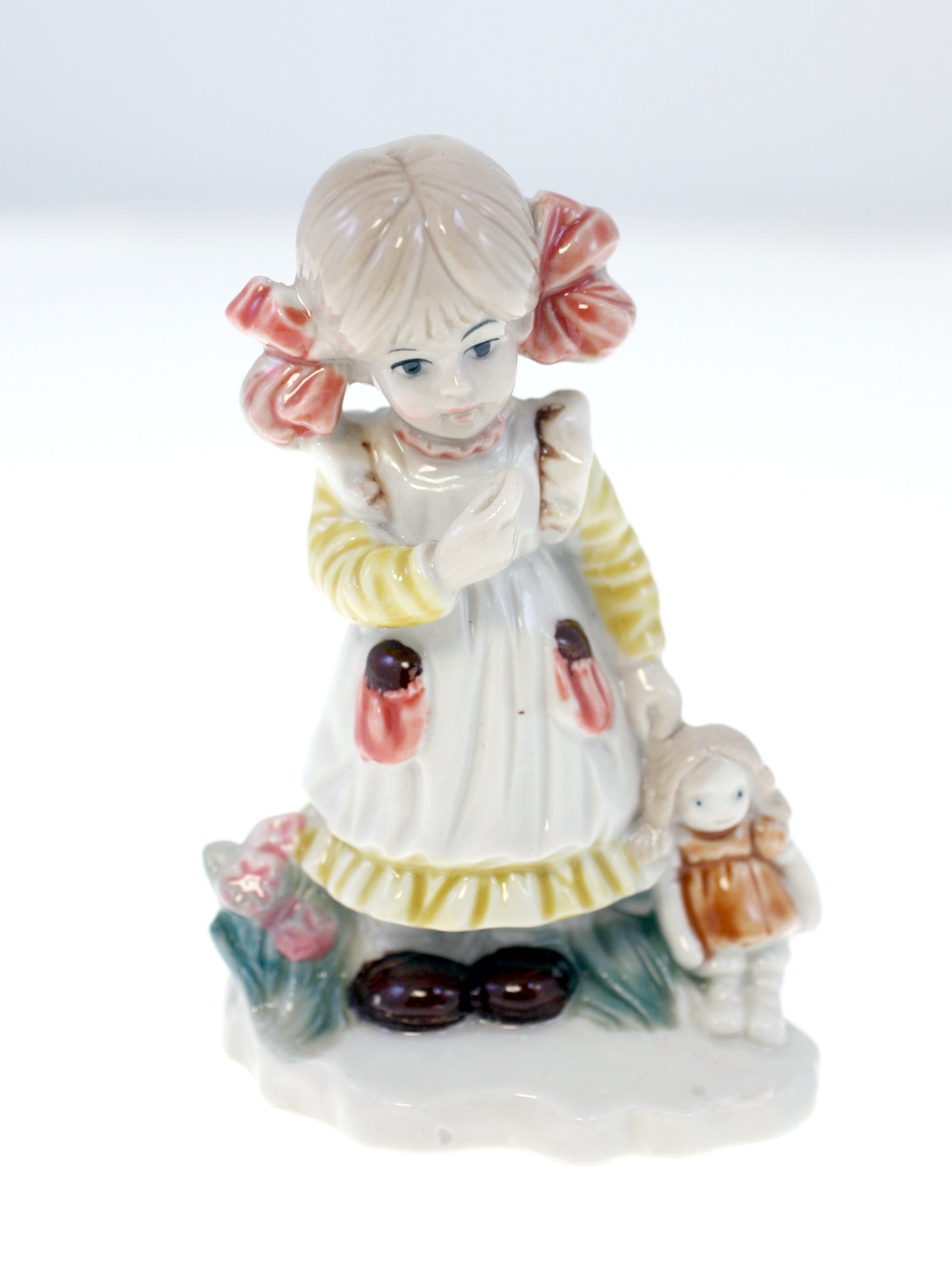 Porcelain figurine of a girl with doll