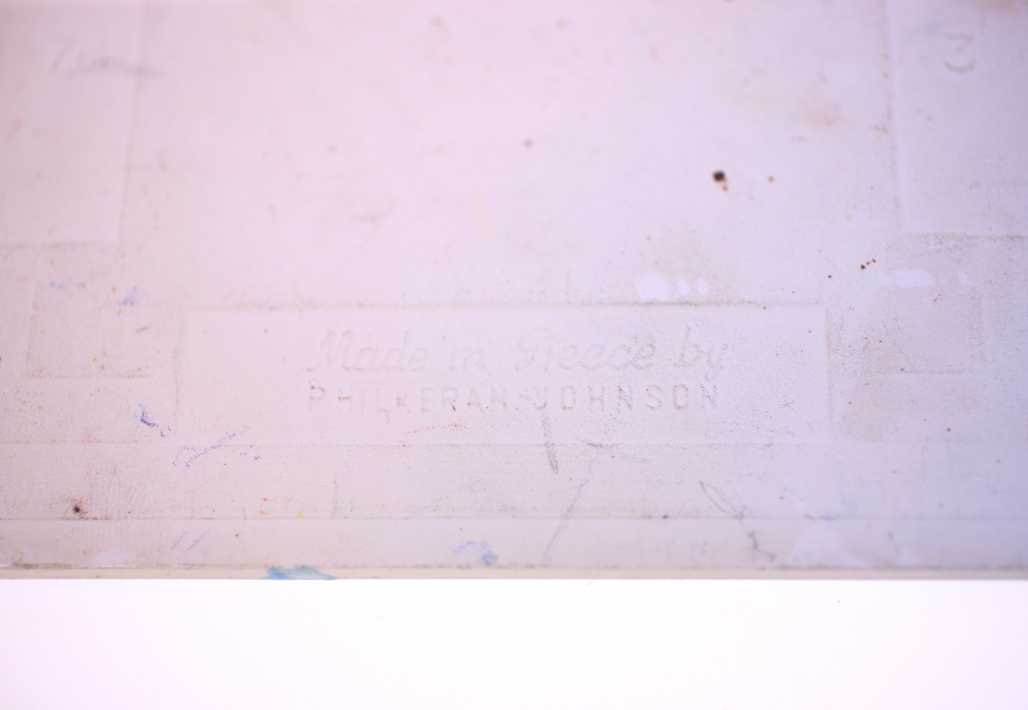 Faded printed label or maker's mark on a plastic/acrylic surface