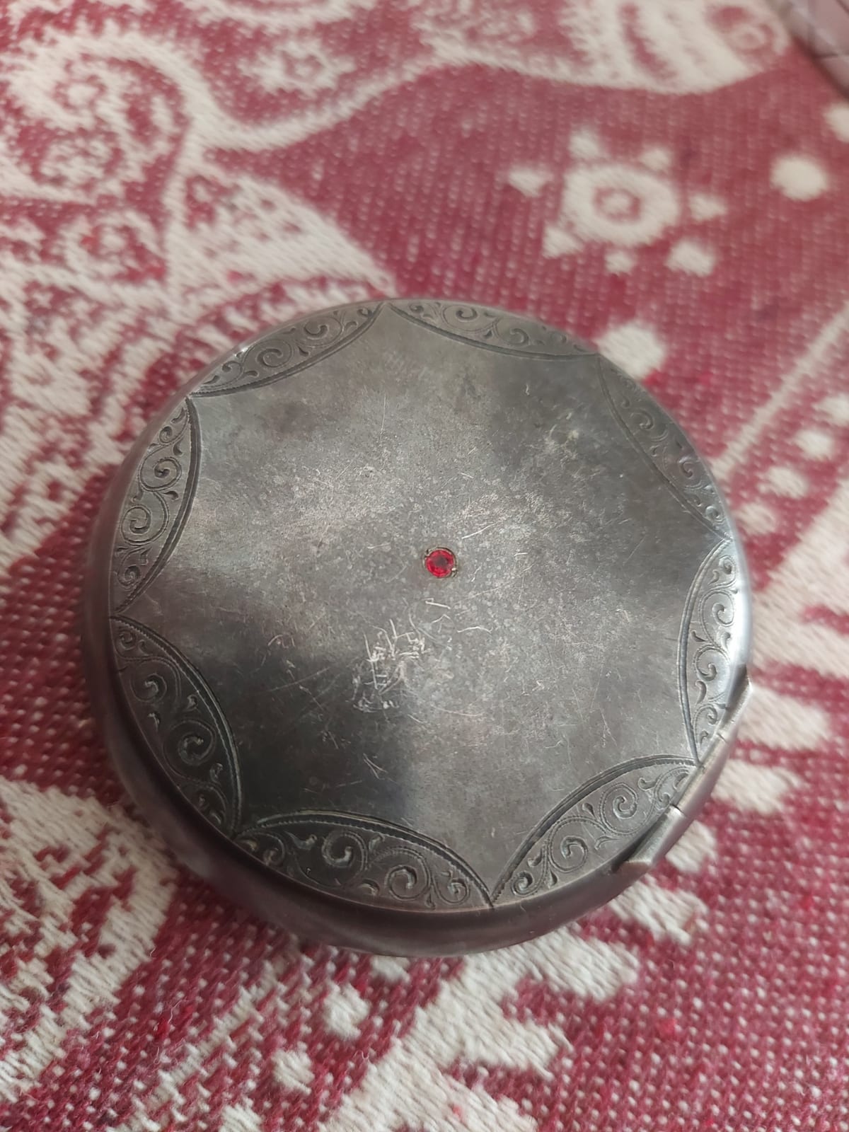 Decorative metal compact or powder case with central red glass stone